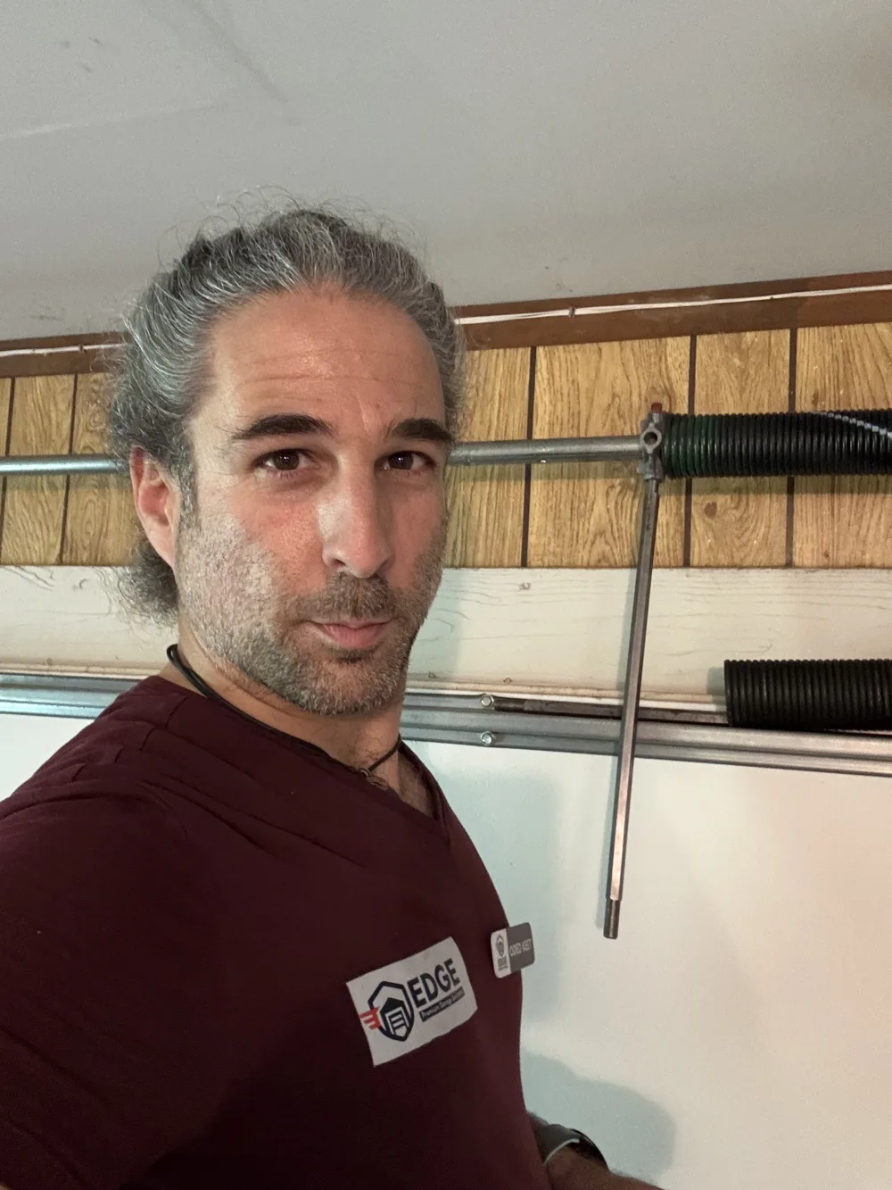 Edge Garage Doors technician replacing a broken garage door spring